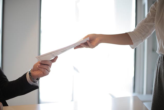 person-handing-another-person-documents person-handing-another-person-documents